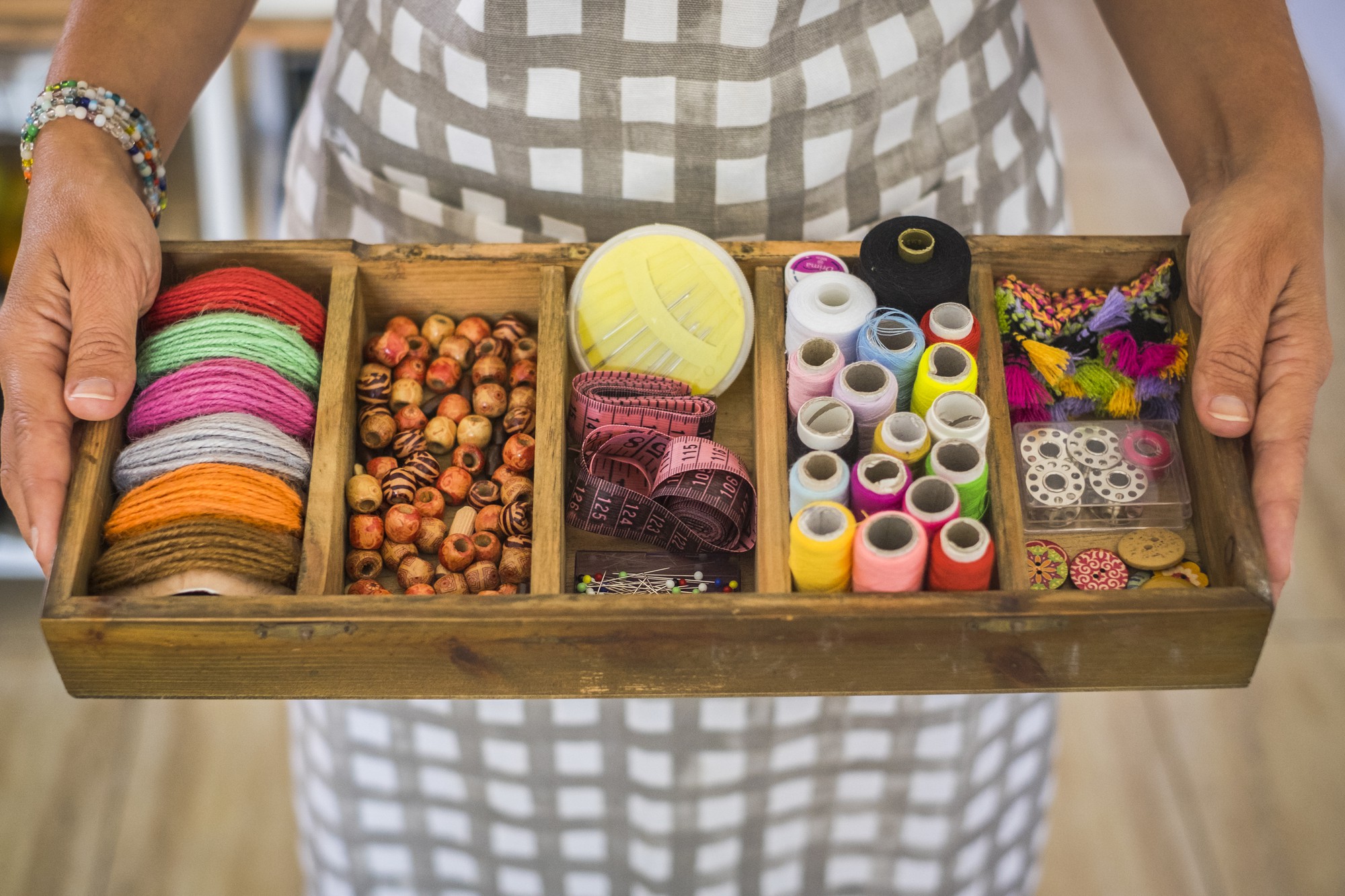 Teacher arranging threads in a wooden tray